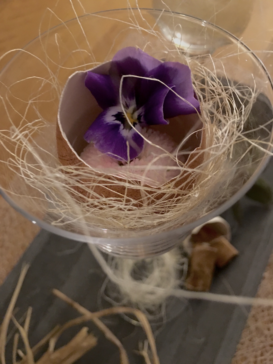 Veilchen in Eischale als Vase auf Nest in Glas